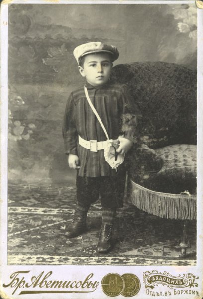 untitled (studio portrait of a small boy with a hat and white belt)